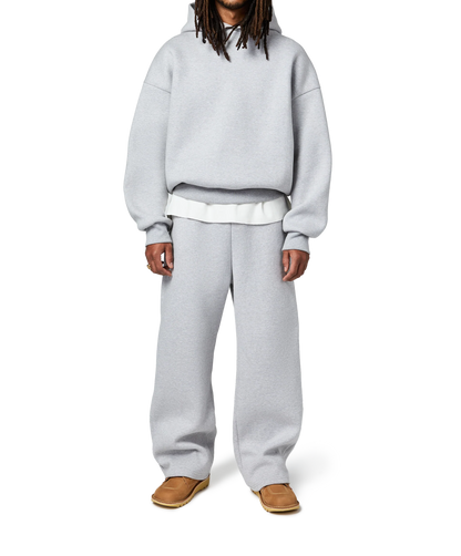 Person wearing a gray hoodie and pants on a white background