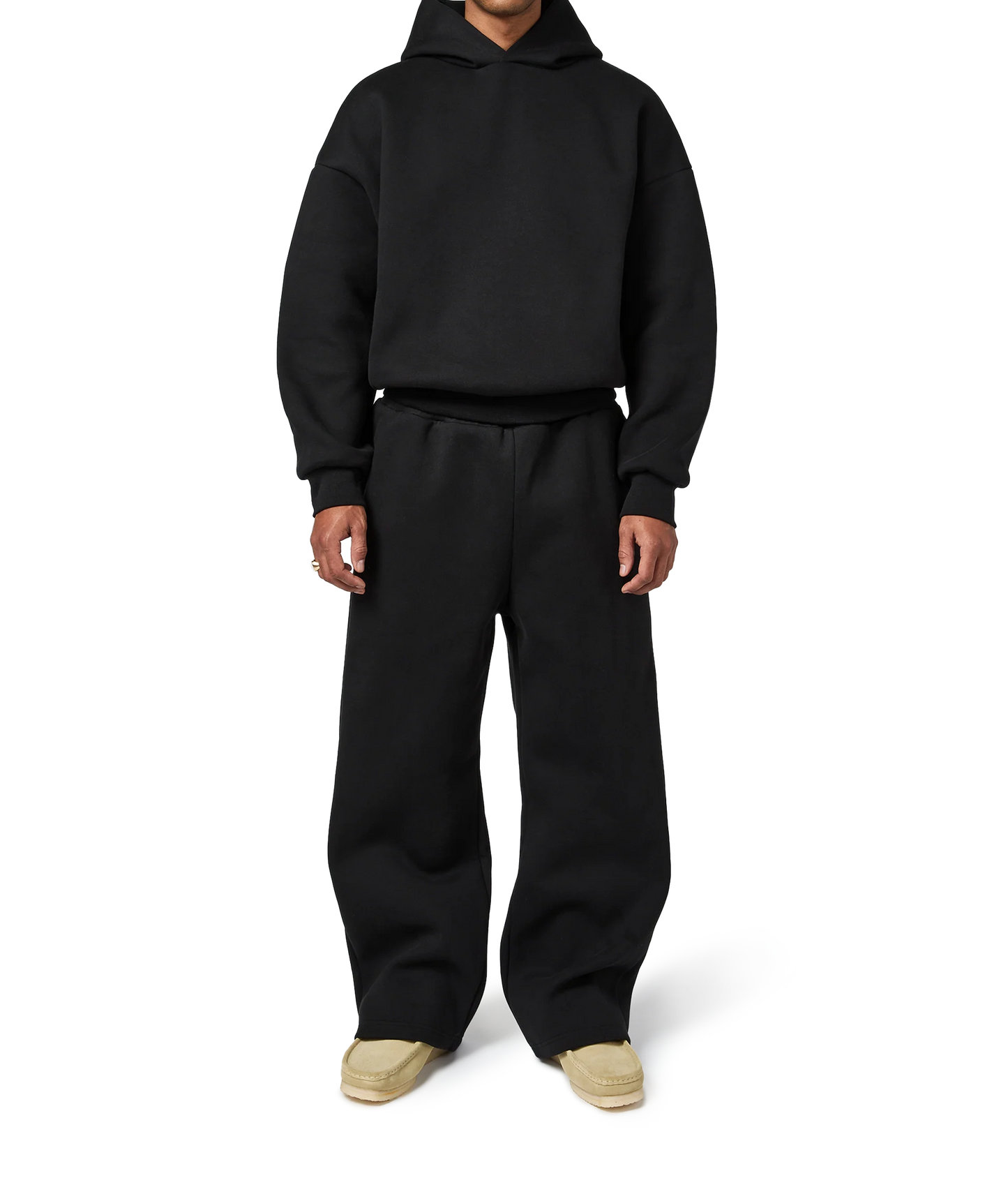 Person wearing a black hoodie and pants on a white background
