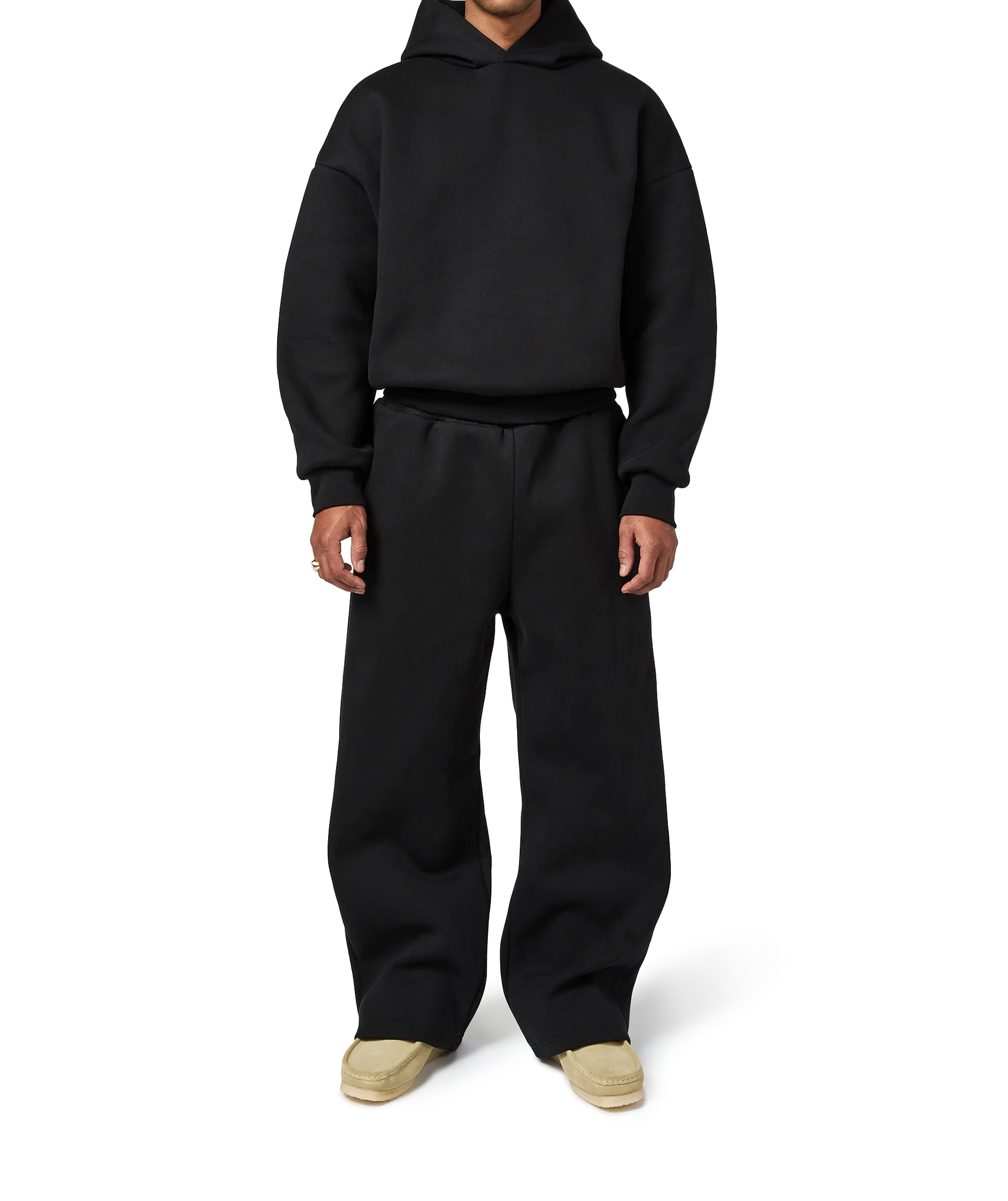 Person wearing a black hoodie and pants on a white background